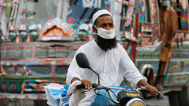 File photo: A man wearing a protective face mask rides a motorbike, as the outbreak of the coronavirus disease (COVID-19) continues, in Karachi, Pakistan June 11, 2020