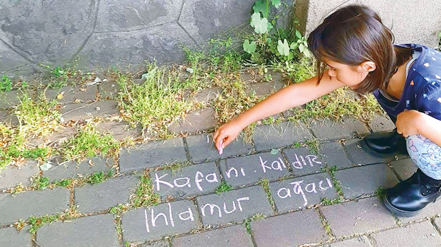Meltem Burcu Arık kızı ile birlikte sokaktaki bitki ve ağaçların ismini yazıyor.