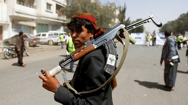 File photo: A Houthi supporter looks on as he carries a weapon during a gathering in Sanaa