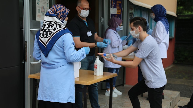 Sınava giren öğrenciler kapılardaki dezenfektanları kullandı. 