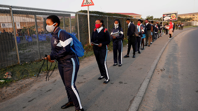 FILE PHOTO: Learners queue before being screened as schools begin to reopen after the coronavirus disease (COVID-19) lockdown in Langa township in Cape Town, South Africa June 8, 2020. 
