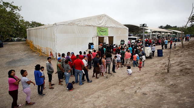 File photo: Migrants seeking asylum in the U.S. queue for food at an encampment of more than 2,000 migrants, as local authorities prepare to respond to the coronavirus disease (COVID-19) outbreak, in Matamoros, Mexico March 20, 2020. Picture taken March 20, 2020