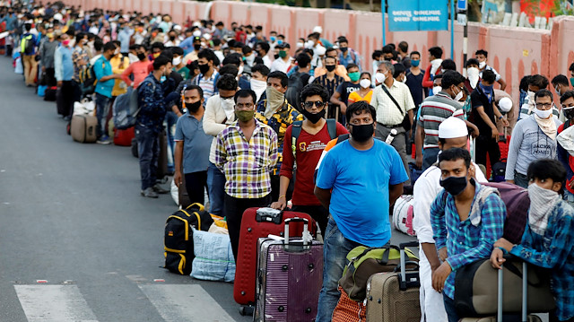 Migrant workers and their families wait in lines outside a railway station to board a train to their home state of eastern West Bengal, after authorities eased lockdown restrictions that were imposed to slow the spread of the coronavirus disease (COVID-19), in Ahmedabad, India, June 18, 2020