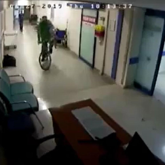 Hastane koridorunda bisiklet süren doktor kamerada