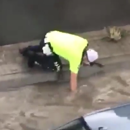 Polis memuru sağanak yağışta tıkanan mazgalı eliyle temizledi