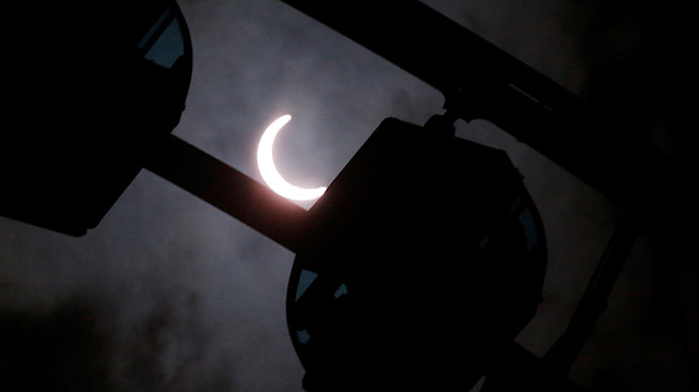 A partial solar eclipse is seen over a ferris wheel, in Hong Kong, China June 21, 2020. 