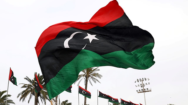 A Libyan man waves a Libyan flag