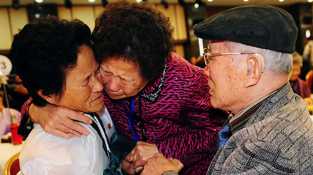 FILE PHOTO: South Korean Kim Sung-bok (R), 90, with an unidentified South Korean family member, meets his daughter Kim Hee-sook (L), 61, during an inter-Korean temporary family reunion at Mount Kumgang resort in North Korea November 3, 2010. Kim Chang-Gil/Korea Pool via REUTERS/File Photo 