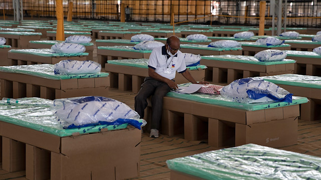 A volunteer sits on a disposable bed made out of cardboard at the campus of Radha Soami Satsang Beas, a spiritual organization, where a coronavirus disease (COVID-19) care centre has been constructed for the patients amidst the spread of the disease, in New Delhi, India, June 25, 2020. 