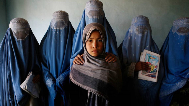 Amina, 13, centre, is surrounded by her classmates at the literacy centre that was set up by the Afghan NGO Humanitarian Assistance for the Women and Children of Afghanistan, in Kabul, Afghanistan. Taken on Monday 30 October 2006, on a Canon EOS 5D. © Jean Chung