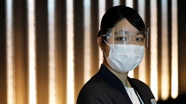 A hotel worker wears a protective mask and goggles at the reception desk of Mitsui Garden Hotel Nihonbashi Premier during the spread of the coronavirus disease (COVID-19) in Tokyo, Japan June 26, 2020.  