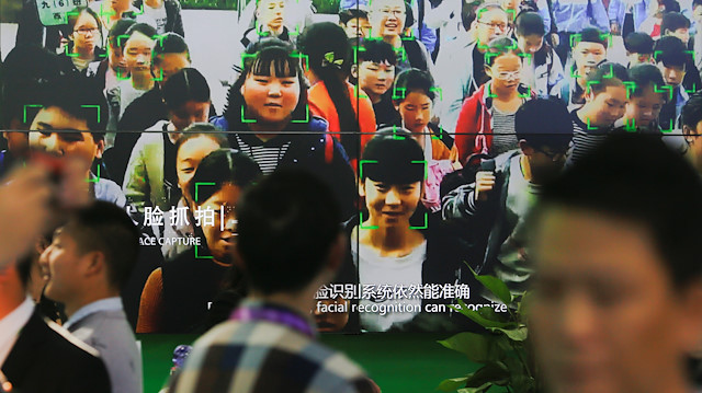 File photo: Visitors walk past a screen showing a demonstration of facial recognition software at the Security China 2018 exhibition on public safety and security in Beijing, China October 23, 2018. Picture taken October 23, 2018