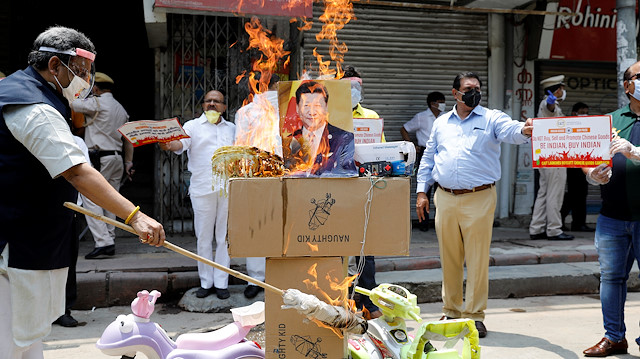 File photo: Demonstrators burn products made in China and a defaced poster of Chinese President Xi Jinping during a protest against China, in New Delhi, India, June 22, 2020. 