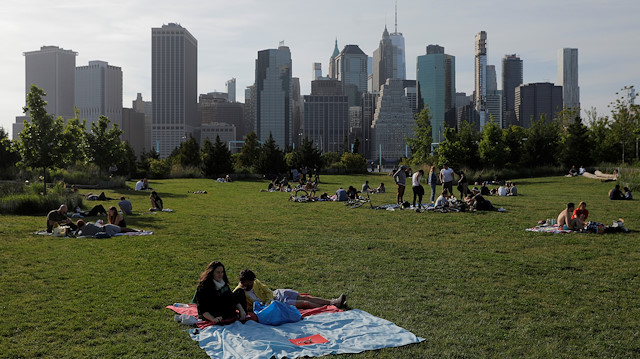 People sit in Brooklyn Bridge Park on front of the skyline of downtown Manhattan on the Memorial Day weekend during the outbreak of the coronavirus disease (COVID-19) in Brooklyn, New York City, U.S., May 24, 2020. 
