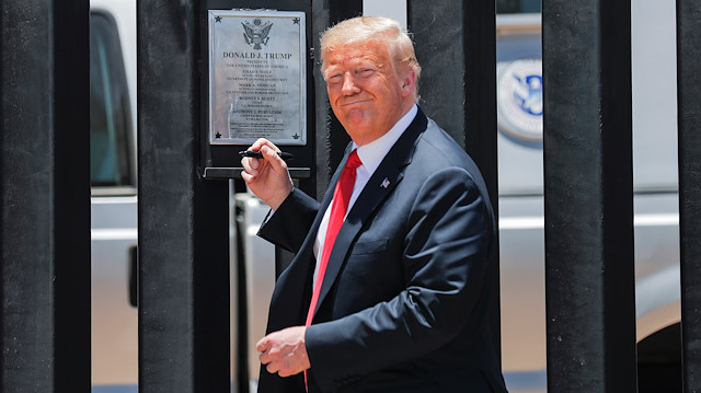 U.S. President Donald Trump smiles as he prepares to autograph a plaque commemorating the construction of the 200th mile of border wall while visiting the wall on the U.S.-Mexico border in San Luis, Arizona, U.S., June 23, 2020. 