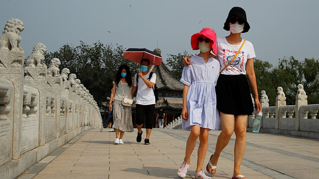 People wearing protective masks walk in the park at Summer Palace on a public holiday, after a new outbreak of the coronavirus disease (COVID-19), in Beijing, China, June 26, 2020. REUTERS/Thomas Peter

