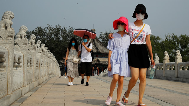 People wearing protective masks walk in the park at Summer Palace on a public holiday, after a new outbreak of the coronavirus disease (COVID-19), in Beijing, China, June 26, 2020. REUTERS/Thomas Peter