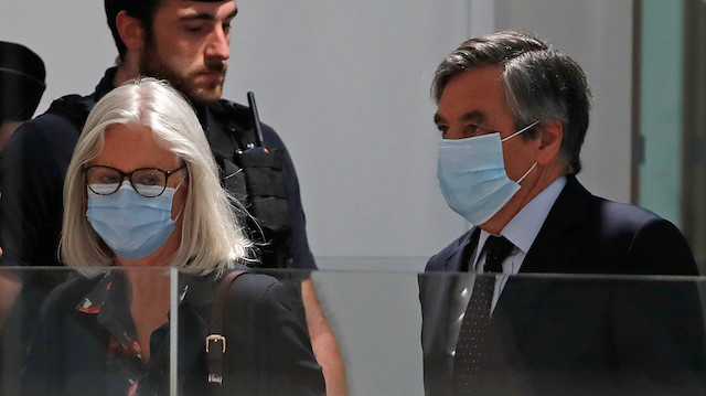 Former French prime minister Francois Fillon and his wife Penelope, wearing protective face masks, arrive for the verdict in their trial over a fake jobs scandal at the courthouse in Paris, France, June 29, 2020.