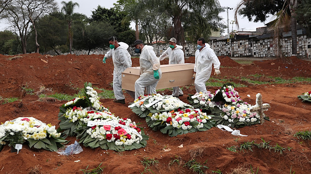 Gravediggers wearing protective suits carry the casket of a 63-year-old woman who died from the coronavirus disease (COVID-19), at Vila Formosa cemetery, in Sao Paulo, Brazil, June 26, 2020. 