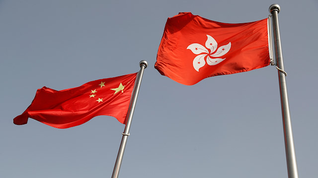 The Chinese and Hong Kong flags flutter at the office of the Government of the Hong Kong 