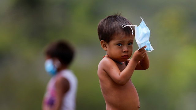 A child from the indigenous Yanomami ethnic group holds his protective face mask, amid the spread of the coronavirus disease (COVID-19), at the 4th Surucucu Special Frontier Platoon of the Brazilian army in the municipality of Alto Alegre, state of Roraima, Brazil July 1, 2020