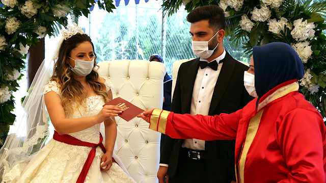 Bride Pelsin Akkoyun and groom Nizamettin Bingol, wearing protective face masks, receive their marriage certificate during a civil wedding ceremony, amid the spread of the coronavirus disease (COVID-19), in Diyarbakir, Turkey, July 2, 2020. Turkey reopened its wedding halls in one of the final steps of reopening from the shutdown due to the coronavirus disease (COVID-19). REUTERS/Sertac Kayar


