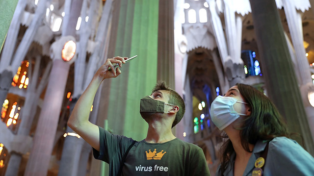 A man uses his phone as health workers, police officers and NGO staff members with their families visit the Sagrada Familia basilica as it reopens following the coronavirus disease (COVID-19) outbreak, in Barcelona, Spain, July 4, 2020