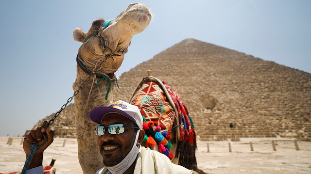 A man with a camel is seen in front of the Great Pyramids of Giza after reopening for tourist visits, following the outbreak of the coronavirus disease (COVID-19), in Cairo, Egypt July 1, 2020. REUTERS/Mohamed Abd El Ghany TPX IMAGES OF THE DAY

