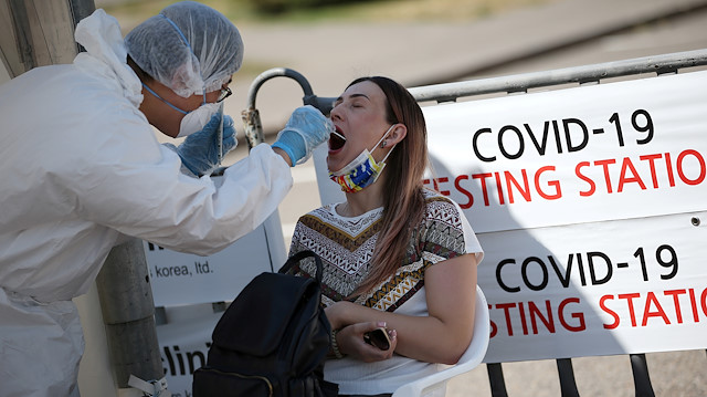 FILE PHOTO: A health worker takes a swab from a woman at a mobile testing station for the coronavirus disease (COVID-19) in Almaty, Kazakhstan June 17, 2020