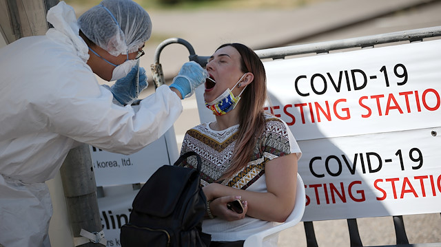 FILE PHOTO: A health worker takes a swab from a woman at a mobile testing station for the coronavirus disease (COVID-19) in Almaty, Kazakhstan June 17, 2020. 