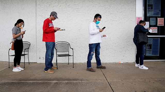 FILE PHOTO: People who lost their jobs wait in line to file for unemployment following an outbreak of the coronavirus disease (COVID-19), at an Arkansas Workforce Center in Fayetteville, Arkansas, U.S. April 6, 2020