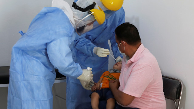File photo: A member of a medical team wearing a protective suit takes a swab from a child to test for the coronavirus disease (COVID-19), at a medical clinic in Tripoli, Libya June 10, 2020. 
