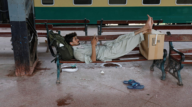 A passenger with his belongings rests on a bench while waiting for a train at the Cantonment railway station, as the outbreak of the coronavirus disease (COVID-19) continues, in Karachi, Pakistan July 8, 2020. REUTERS/Akhtar Soomro

