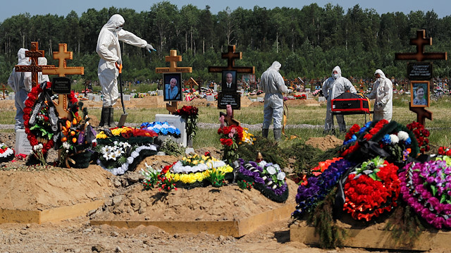 File photo: Grave diggers wearing personal protective equipment (PPE) bury a person, who presumably died of the coronavirus disease (COVID-19), in the special purpose section of a graveyard on the outskirts of Saint Petersburg, Russia June 26, 2020