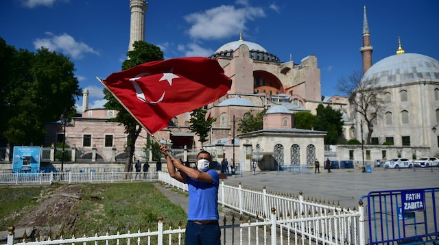Ayasofya'ya gelen vatandaşlar Türk bayrakları ile fotoğraf çektiriyor.