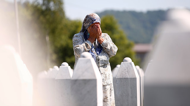 A woman prays at a graveyard, ahead of a mass funeral in Potocari near Srebrenica, Bosnia and Herzegovina July 11, 2020. Bosnia marks the 25th anniversary of the massacre of more than 8,000 Bosnian Muslim men and boys, with many relatives unable to attend due to the coronavirus disease (COVID-19) outbreak. 