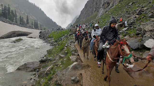 FILE PHOTO: Hindu pilgrims travel, either on ponies or on foot, along a track besides a glacier-fed stream during their annual pilgrimage to holy cave of Lord Shiva, in Pishutop, 114 km (71 miles) southeast of Srinagar June 25, 2012. REUTERS/Fayaz Kabli/File Photo

