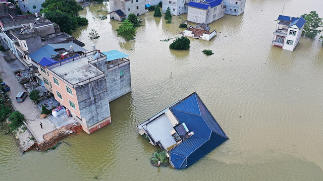A building that has fallen over after flooding is seen partially submerged in floodwaters following heavy rainfall in the region, at a village near Poyang Lake, in Poyang county, Jiangxi province, China July 13, 2020.
