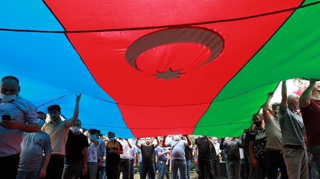 People hold the national flag during the funeral of Major General Polad Gashimov and Colonel Ilgar Mirzoyev of the Armed Forces of Azerbaijan, who were killed in armed clashes on the border between Azerbaijan and Armenia earlier this week, in Baku, Azerbaijan July 15, 2020. REUTERS/Vali Shukurov


