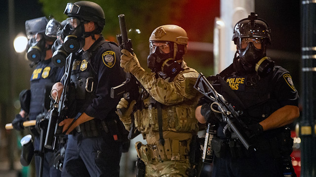 Federal law enforcement officers, deployed under the Trump administration's new executive order to protect federal monuments and buildings, face off with protesters against racial inequality in Portland, Oregon, U.S. July 18, 2020