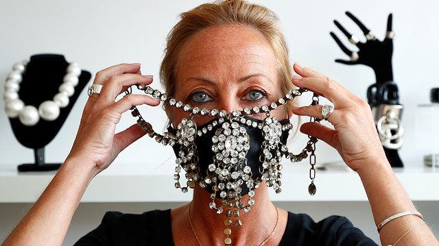 Belgian jewellery designer Olivia Hainaut poses wearing a protective mask decorated with gems in her workshop amid the coronavirus disease (COVID-19) outbreak in Brussels, Belgium July 22, 2020. Picture taken July 22, 2020. REUTERS/Francois Lenoir

