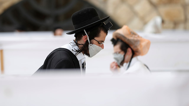 Jewish worshippers wear face masks