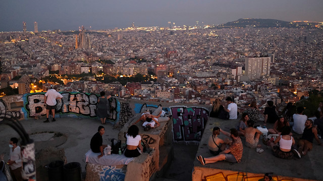Tourists and locals gather at a lookout point, with a view of the city of Barcelona in the background, after regional authorities across Spain introduced fresh coronavirus disease (COVID-19) restrictions aimed at stamping out a surge in infections, in Barcelona, Spain July 23, 2020.