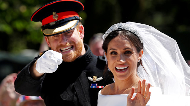 FILE PHOTO: Britain’s Prince Harry gestures next to his wife, Meghan, as they ride a horse-drawn carriage after their wedding ceremony at St George’s Chapel in Windsor Castle in Windsor, Britain, May 19, 2018. REUTERS/Damir Sagolj/File Photo

