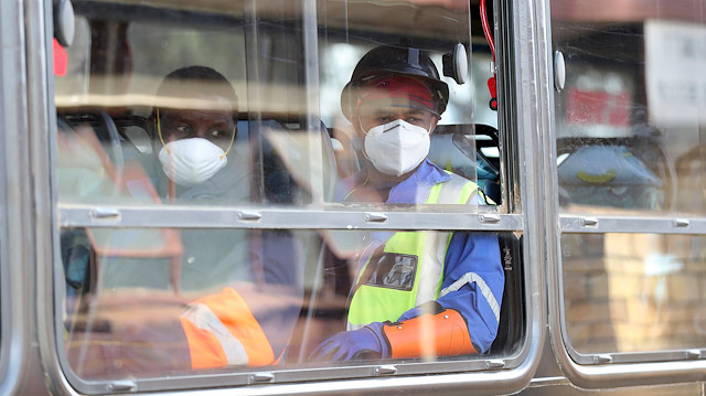 FILE PHOTO: Mine workers wearing face masks looks on at the end of their shift, amid a nationwide coronavirus disease (COVID-19) lockdown, at a mine of Sibanye-Stillwater company in Carletonville, South Africa, May 19, 2020. REUTERS/Siphiwe Sibeko/File Photo

