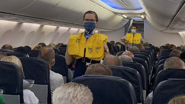 FILE PHOTO: Flight attendants of TUI Fly wear face masks as they give instructions to German tourists on the first flight from Duesseldorf to Mallorca, two weeks before Spain starts reopening borders closed since mid-March to curb the coronavirus disease (COVID-19) pandemic, in Duesseldorf, Germany, June 15, 2020. REUTERS/Erol Dogrudogan/File Photo

