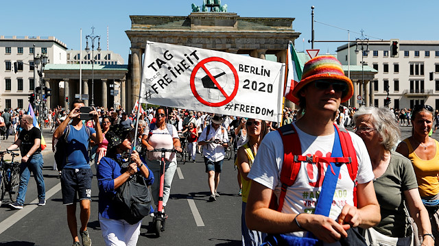 Demonstrators hold a banner during a protest against the government's restrictions amid the coronavirus disease (COVID-19) outbreak, in Berlin, Germany, August 1, 2020. REUTERS/Fabrizio Bensch

