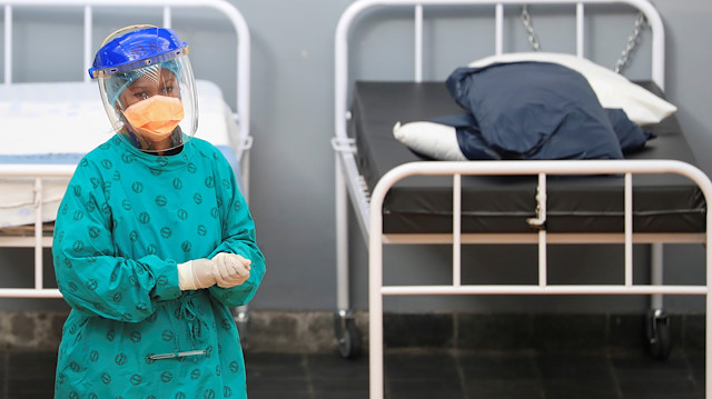  A health worker walks between beds at a temporary field hospital 