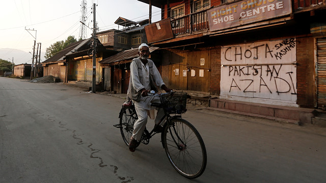 A Kashmiri man rides his bicycle past a shop painted with graffiti in Anchar neighbourhood in Srinagar July 28, 2020. Picture taken July 28, 2020.