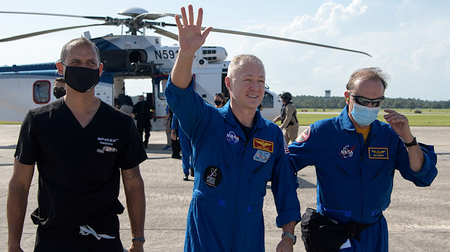 NASA astronaut Douglas Hurley waves to onlookers as he boards a plane at Naval Air Station Pensacola to return him and NASA astronaut Robert Behnken home to Houston a few hours after the duo landed in their SpaceX Crew Dragon Endeavour spacecraft off the coast of Pensacola, Florida, U.S. August 2, 2020. NASA/Bill Ingalls/Handout via Reuters
